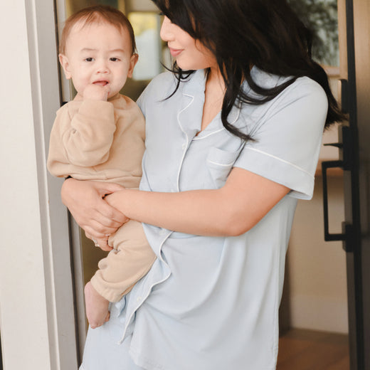 Model holding baby while wearing the Clea Bamboo Short Sleeve Pajama Set in Mist